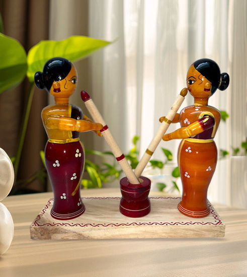 Vibrant Channapatna wooden figurines of women, each with a stick, showcasing traditional Indian craftsmanship and culture.
